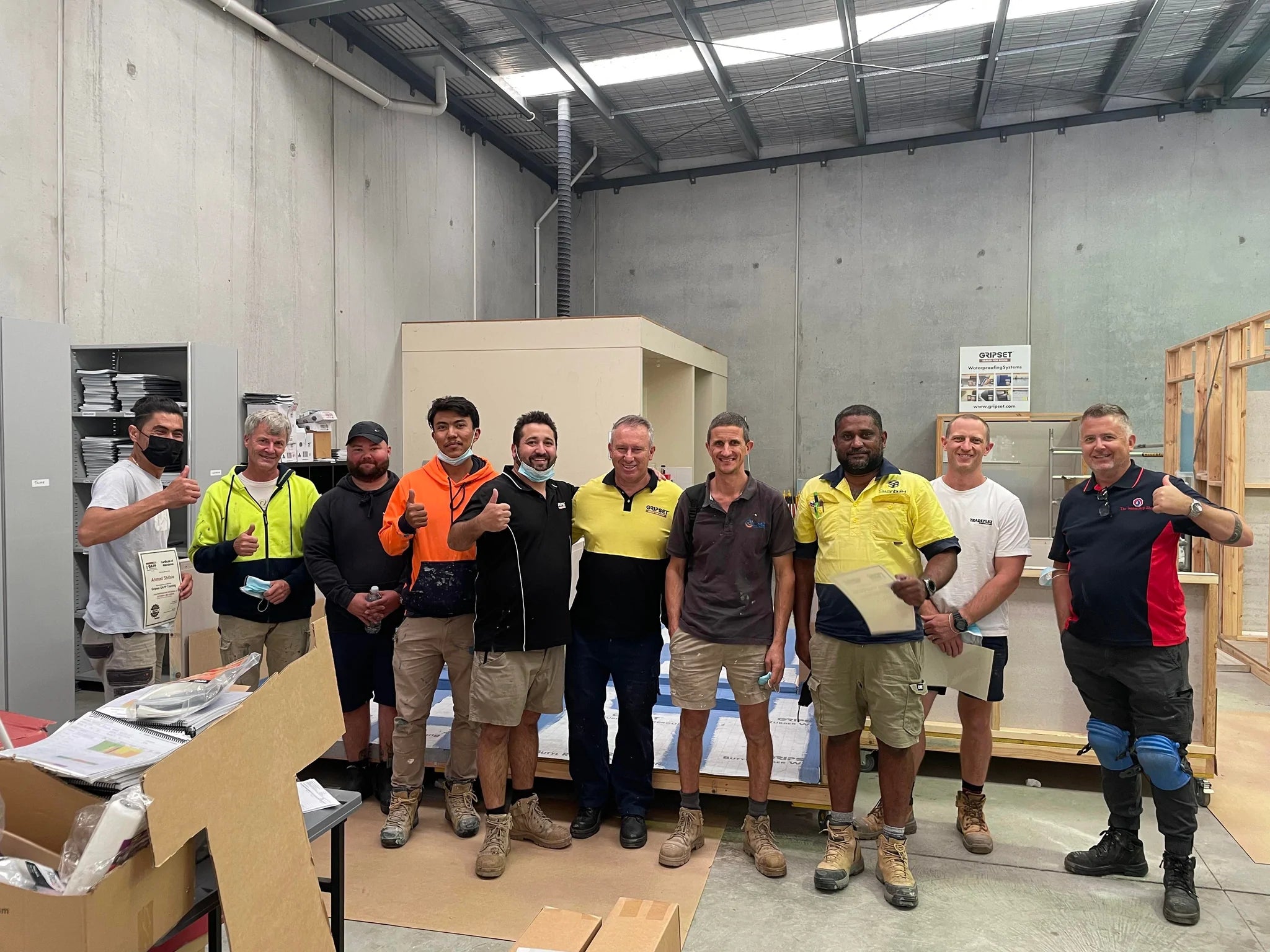 a group of male waterproofers standing with their certificates after completeing their waterproofing training at GAPP 